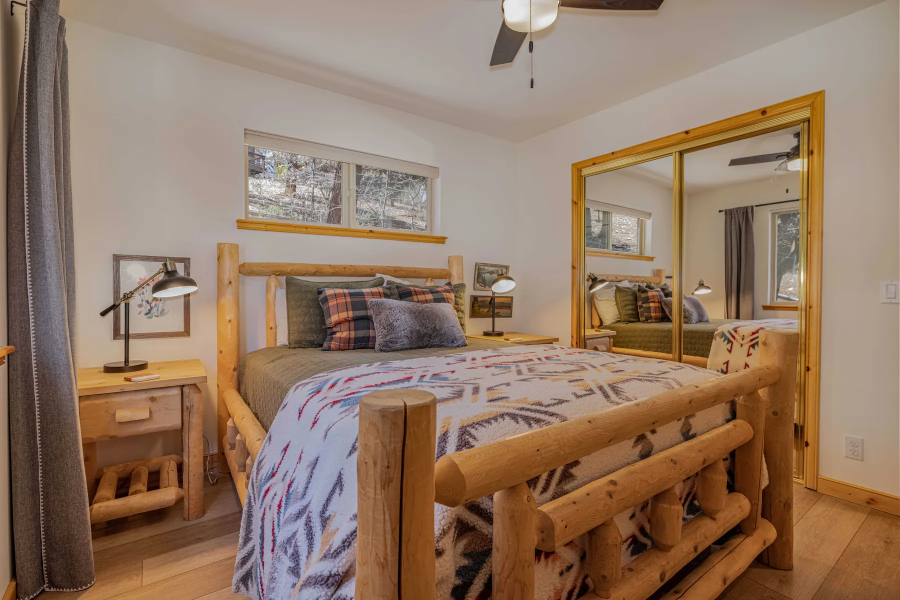 Bedroom Two at Pine Grove Cabin showing the queen bed and mirrored closet doors