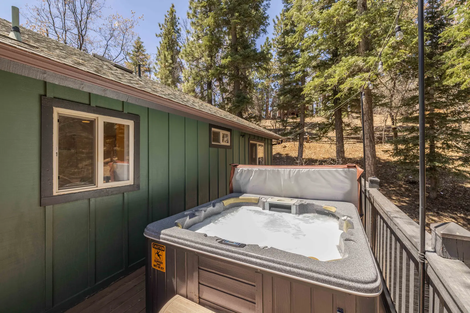 Propane BBQ grill on the deck at Pine Grove Cabin, surrounded by pine trees