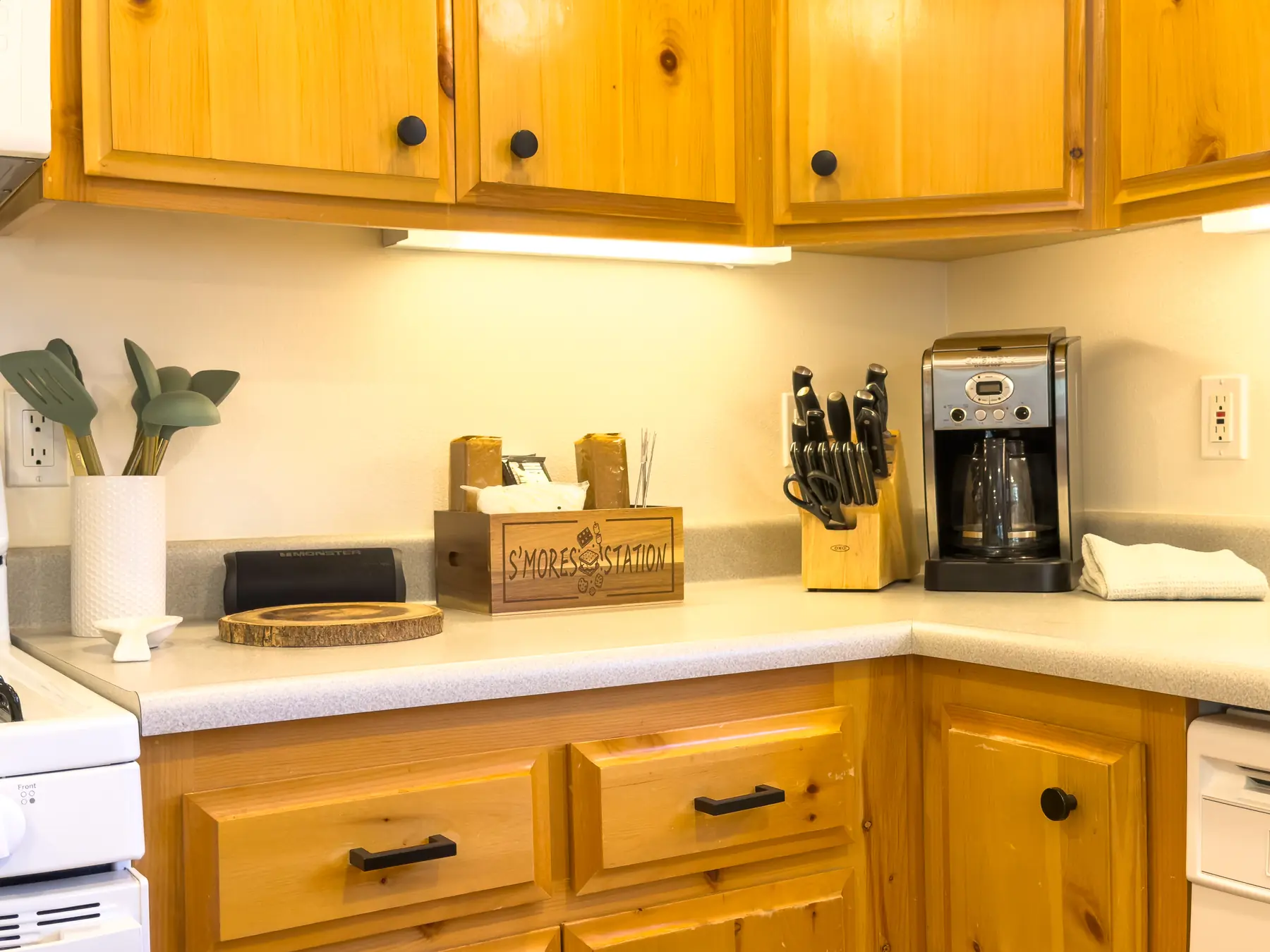 Kitchen counter at Pine Grove Cabin with a s'mores station, coffee maker, and knife block